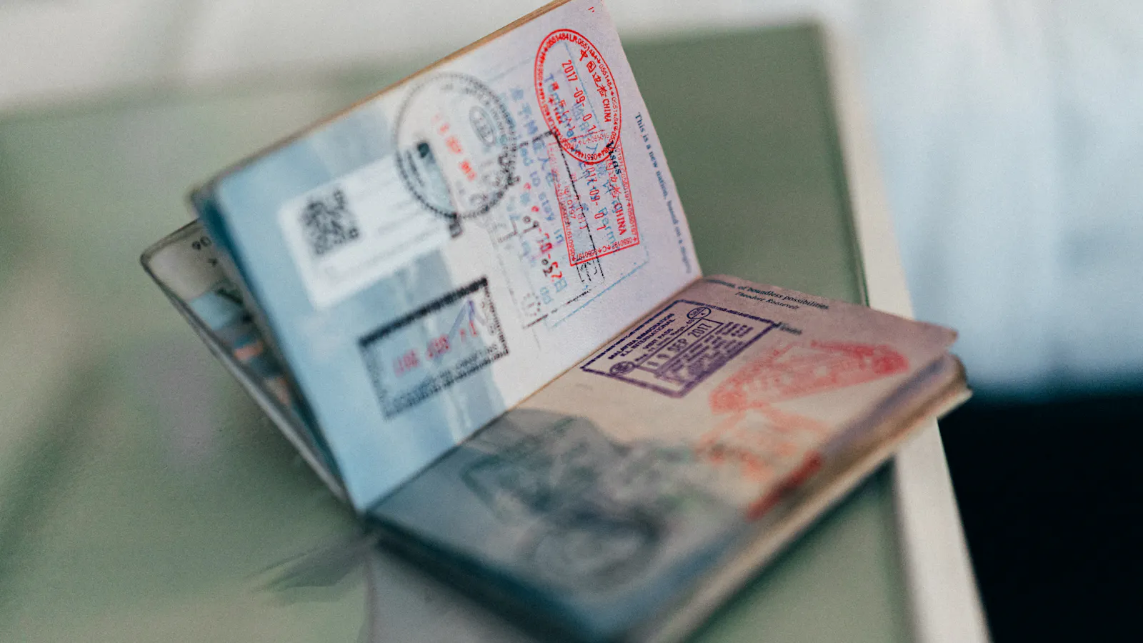 Open passport with several colourful entry stamps
