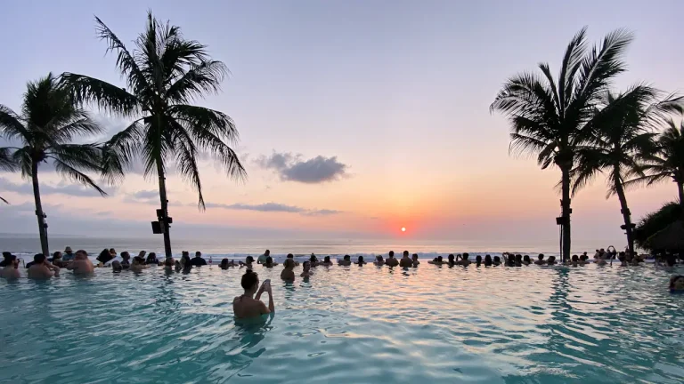 Infinity pool at sunset with palm trees in Bali