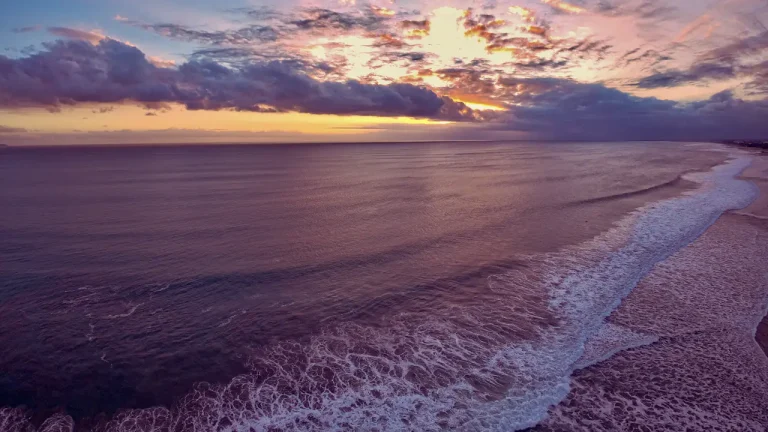 Waves crashing on the shore at sunset in Bali