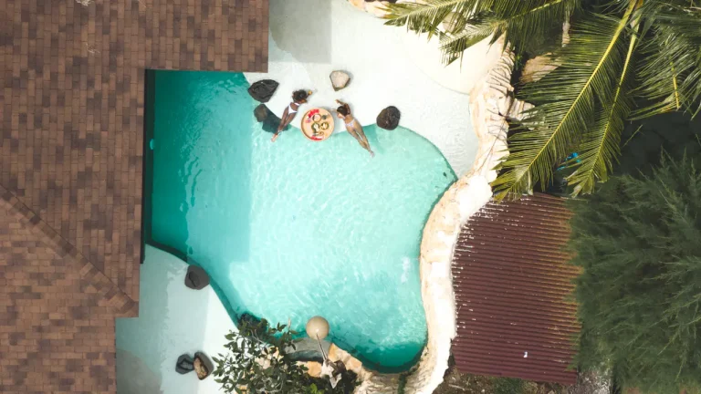 Aerial view of a resort pool surrounded by palm trees in Bali