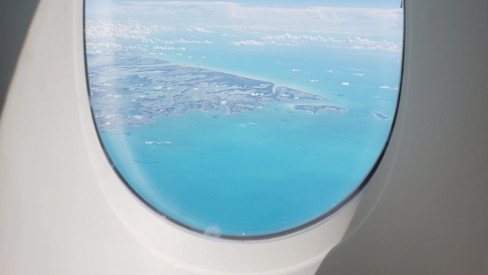 Aeroplane wing in the air above a body of water