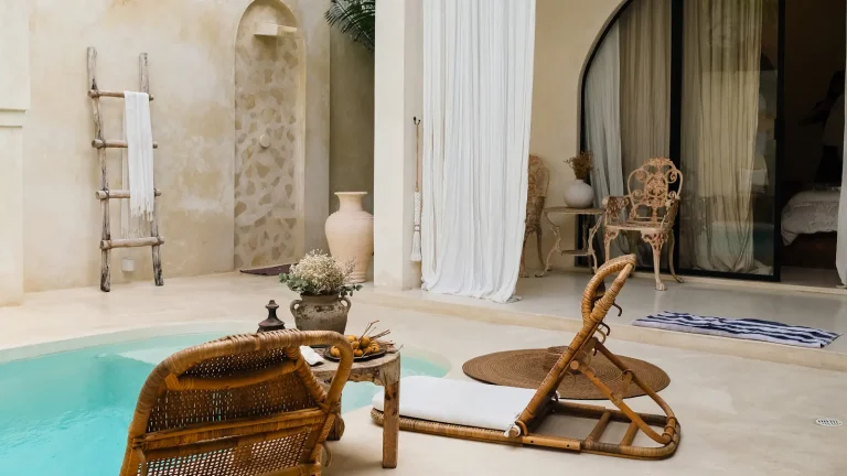 Villa pool with a lounge chair and a table beside it