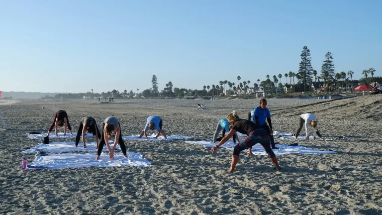 Group stretching on yoga mats on a beach