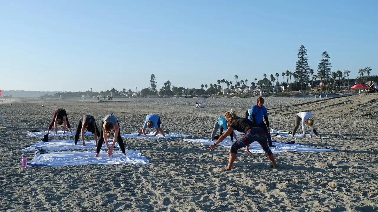 Group stretching on yoga mats on a beach