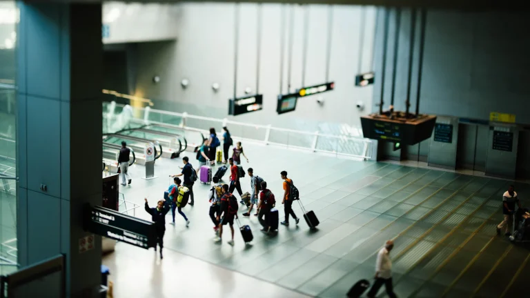 Travellers with luggage walking through a modern airport terminal